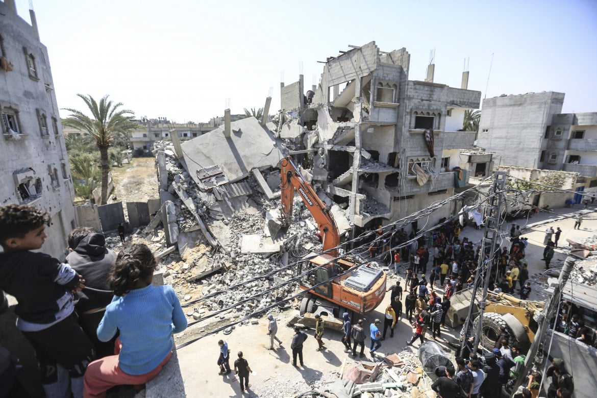 Soccorritori e civili alla ricerca di sopravvissuti al bombardamento israeliano della casa della famiglia Zorob, nella città di Rafah foto Ap/Mohammed Talatene