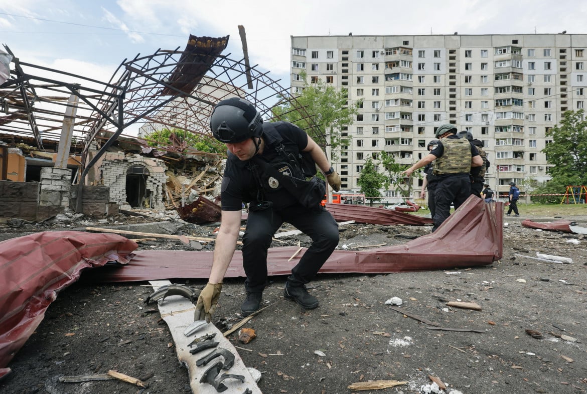 Poliziotti sul luogo di un bombardamento a Kharkiv foto Epa/Sergey Kozlov