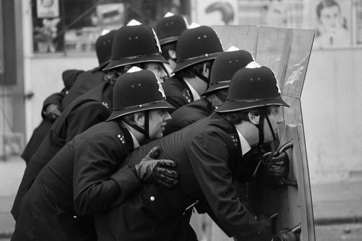 Aprile 1981, un gruppo di bobbies impegnati a contrastare le proteste scoppiate per le strade di Brixton, a Londra