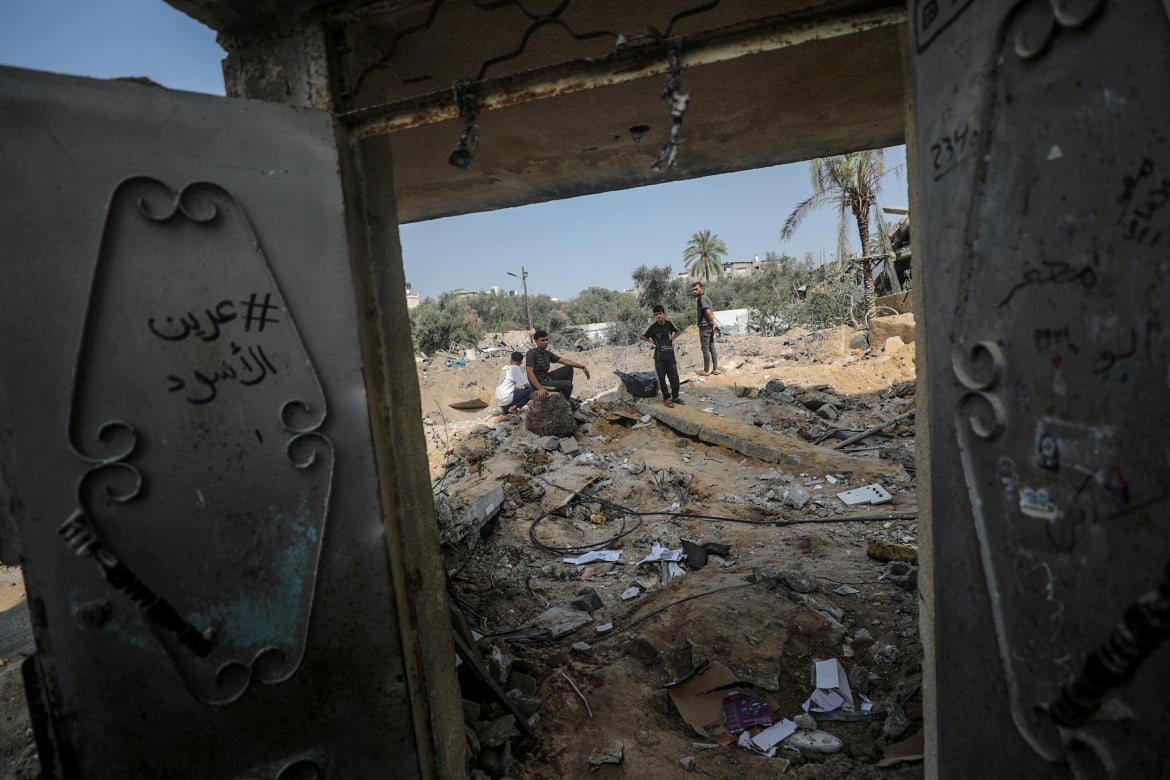 Ragazzi palestinesi tra le rovine di una casa del campo di Al Nuseirat a Gaza foto Mohammed Saber/Ansa
