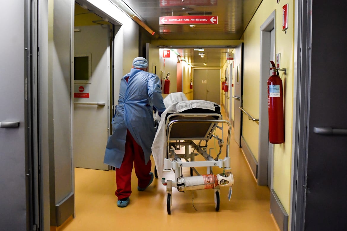 Un paziente viene portato su una barella tra i corridoi dell’ospedale di Bergamo foto LaPresse