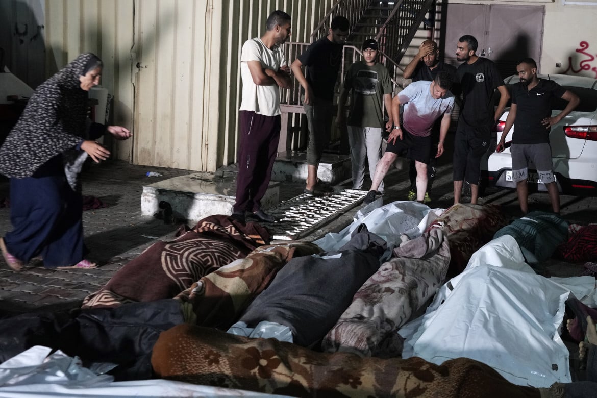 Palestinesi alla morgue dell’ospedale di Al Aqsa dopo la strage alla scuola Unrwa di Nuseirat