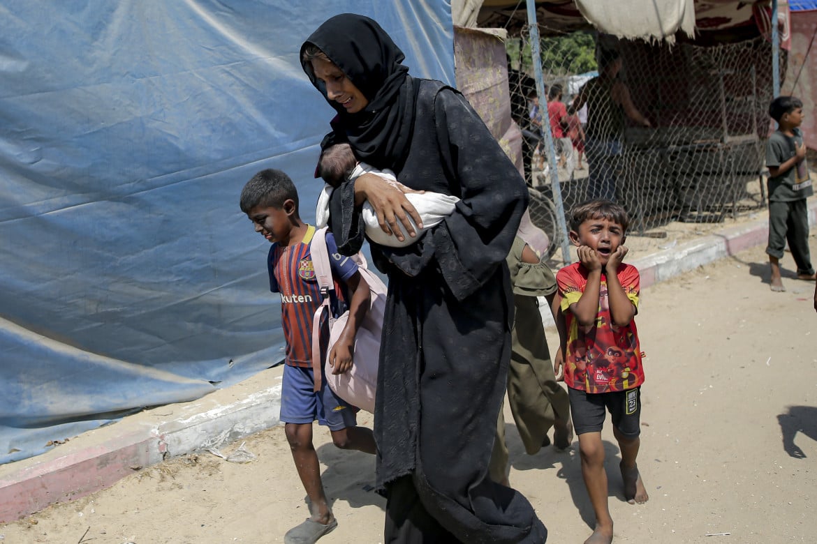 Khan Younis. Una donna e i suoi figli in fuga dopo il bombardamento israeliano