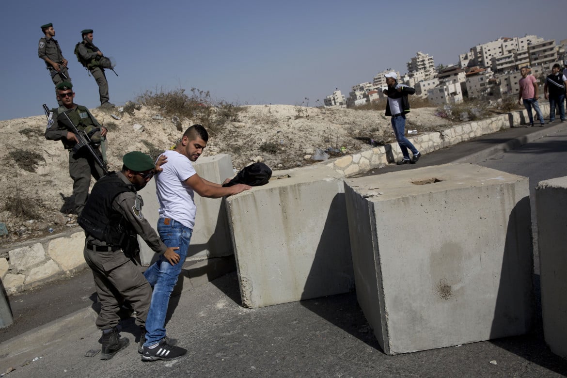 La polizia perquisisce un giovane palestinese all’ingresso di un quartiere a Gerusalemme est Ap/Oded Balilty