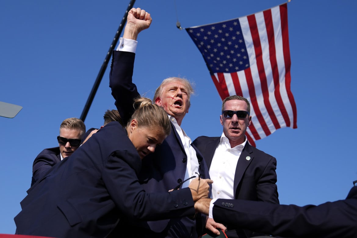 Una foto già iconica: Donald Trump circondato dagli agenti dei servizi segreti pochi istanti dopo l'attentato a Butler in Pennsylvania il 13 luglio 2024