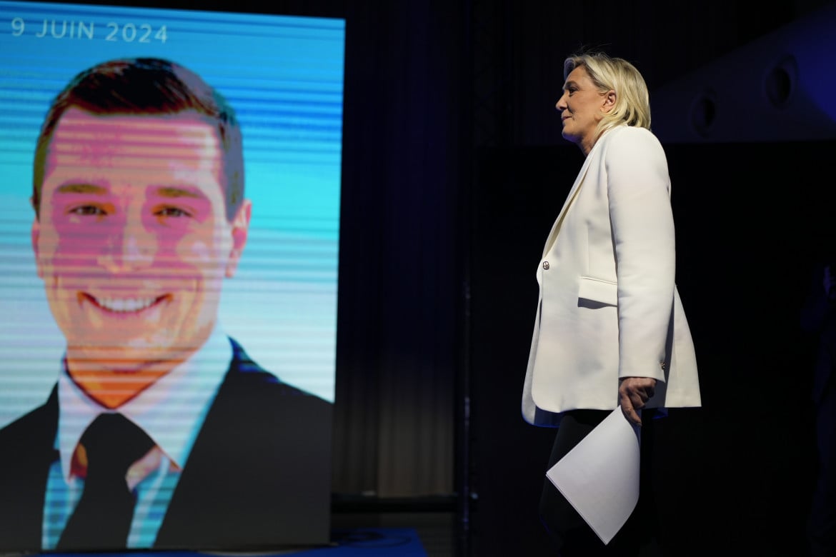 Marine Le Pen, sullo schermo Jordan Bardella (AP Photo/Lewis Joly)