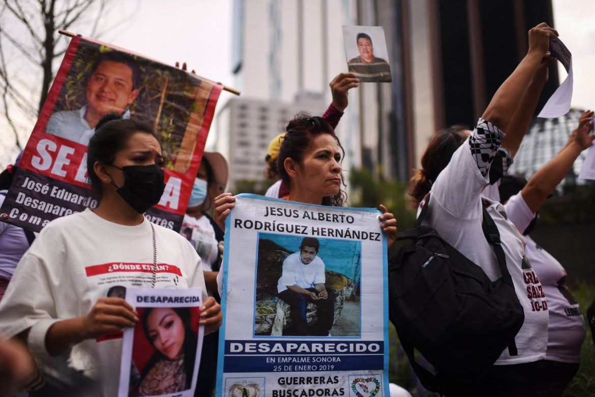 Familiari di persone scomparse tengono le loro foto durante una manifestazione nell'ambito della Giornata internazionale degli scomparsi a Città del Messico foto di Pedro Pardo/Getty Images